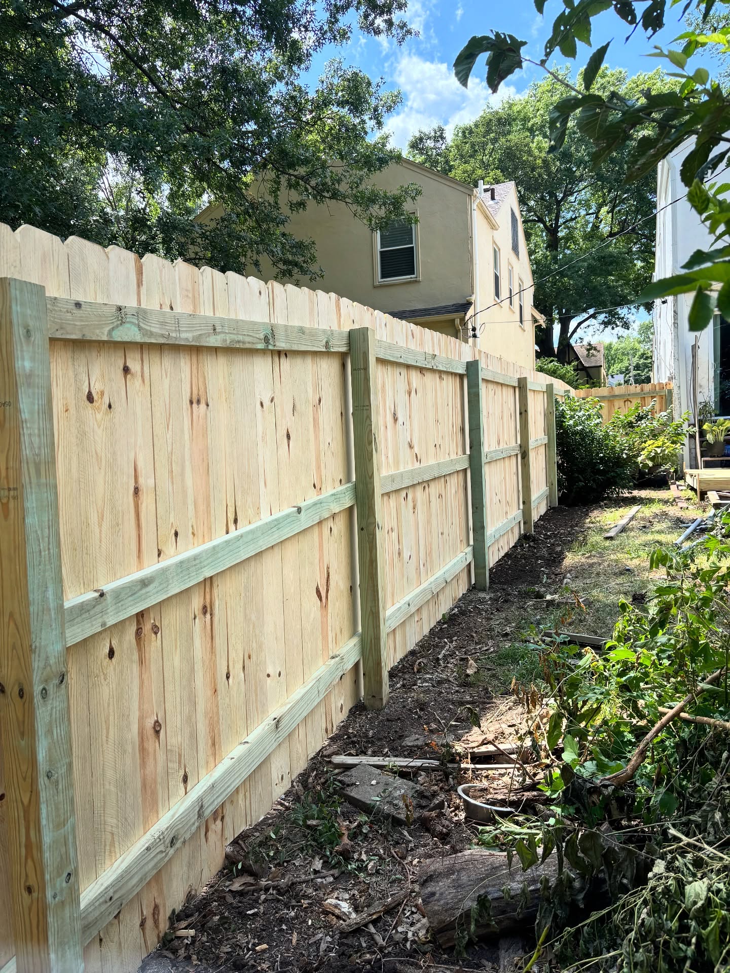 Rebuilt fence section with new posts and concrete footings after Kansas City storm damage — RKC Wood Care Pros