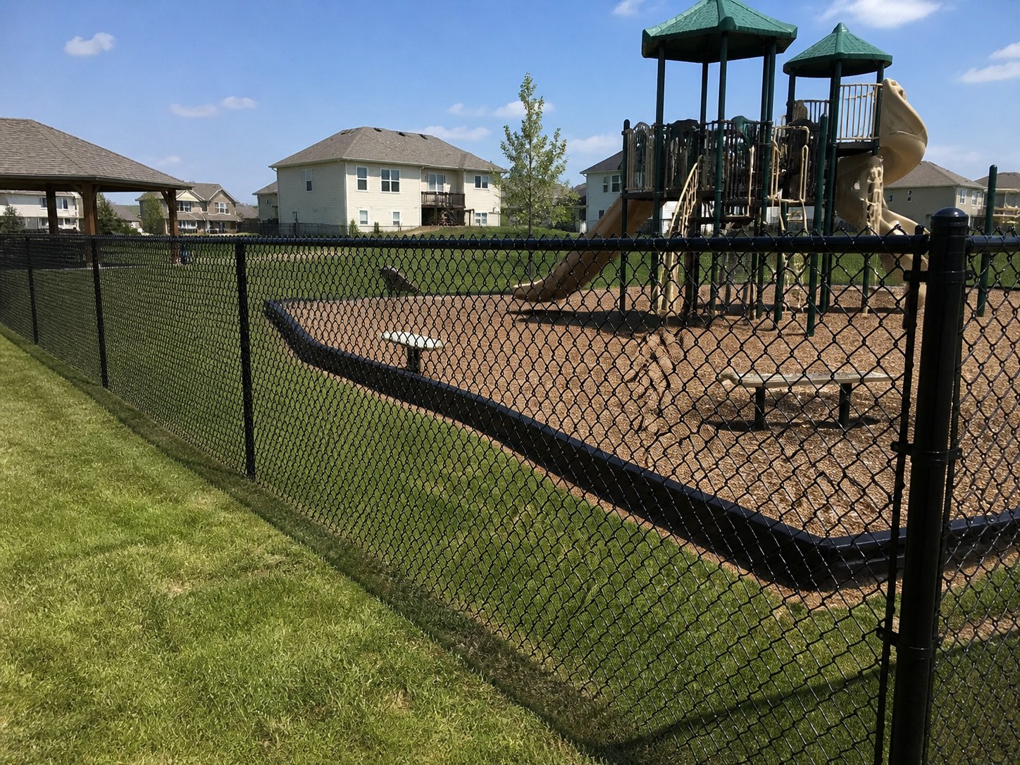 Black vinyl-coated chain link fence — Oak Grove, MO installation FAQ — RKC Wood Care Pros