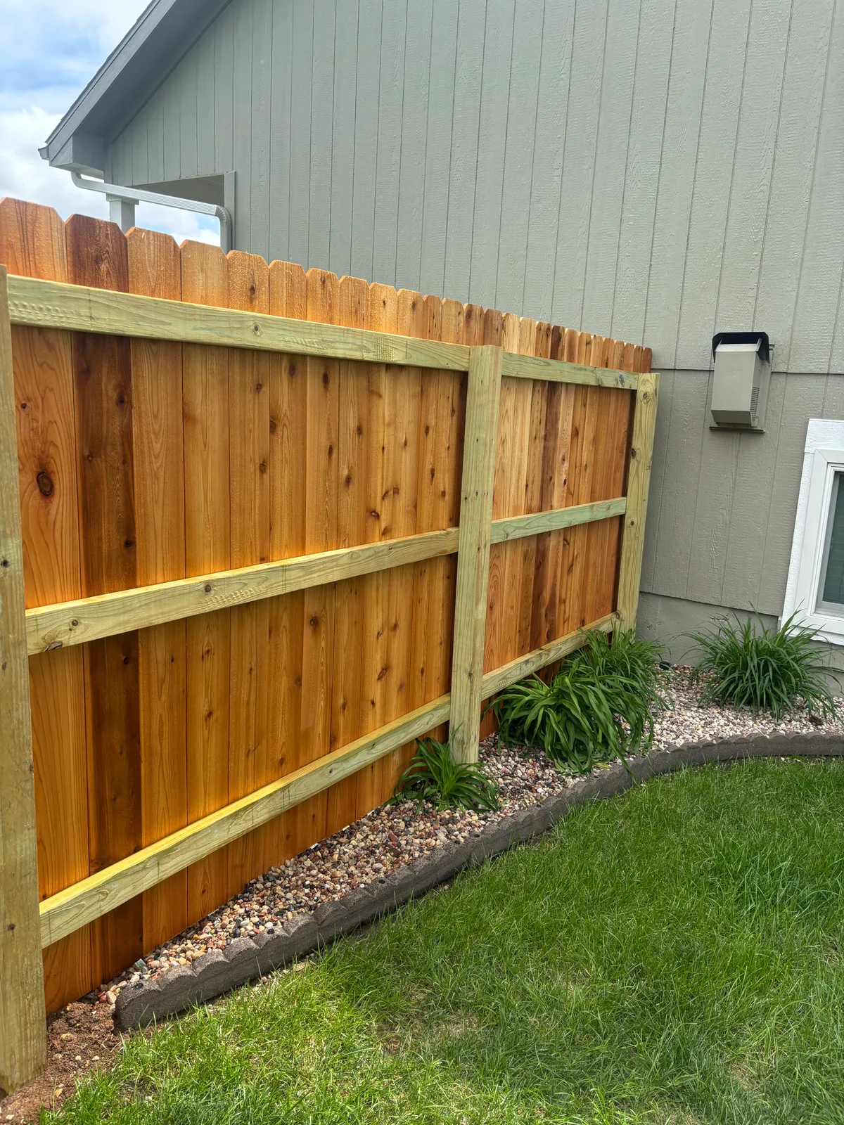 Board-face view of cedar privacy fence posts and rails in Blue Springs, MO backyard
