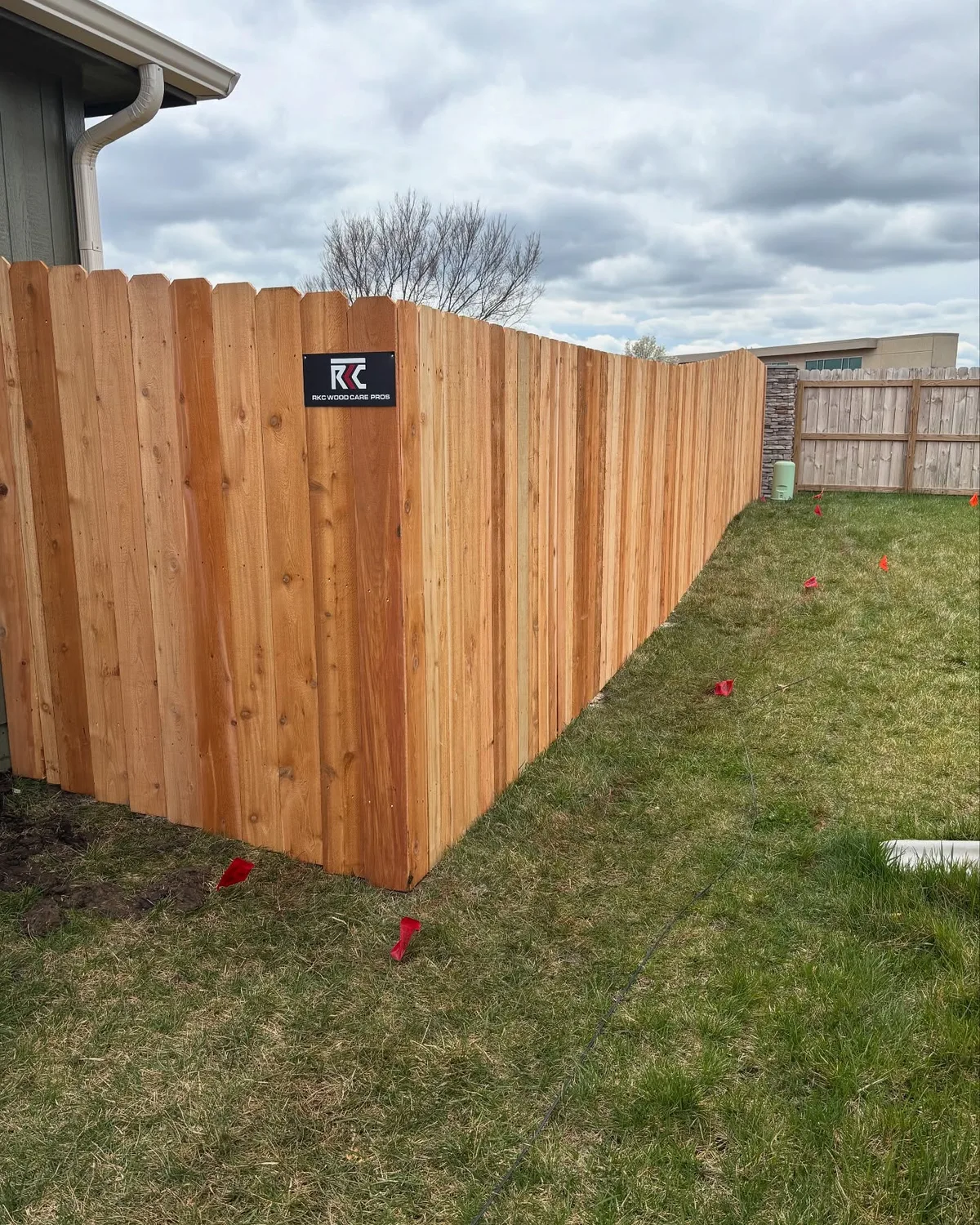 Full run of new cedar privacy fence with green pressure-treated posts in Olathe, KS